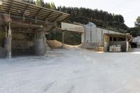 sand being turned to sand by the truck as it drives around a building structure with a covered roof