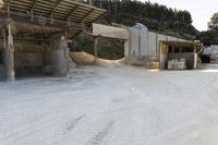 sand being turned to sand by the truck as it drives around a building structure with a covered roof