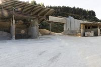 sand being turned to sand by the truck as it drives around a building structure with a covered roof