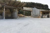 sand being turned to sand by the truck as it drives around a building structure with a covered roof