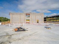 construction work on the side of a building near a craned down sign post and concrete floor