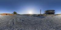 a picture of a person walking on top of sand at a construction site with a building and structure in the background