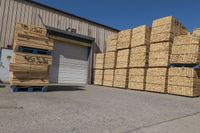 stacks of straw sitting outside a storage warehouse building under construction area with a truck behind it