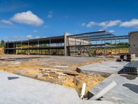 an unfinished building with steel framed walls being built by construction workers and a blue sky