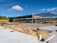 an unfinished building with steel framed walls being built by construction workers and a blue sky