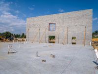 construction site for large house with brick work and concrete floors and walls and pillars around the window