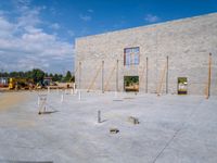 construction site for large house with brick work and concrete floors and walls and pillars around the window