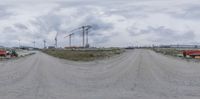 a 3d image of construction work on an empty road near the beach under cloudy skies