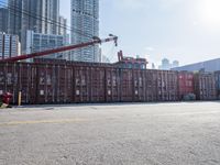 a construction worker stands near container boxes outside a building area with other containers in the background