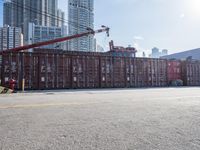 a construction worker stands near container boxes outside a building area with other containers in the background