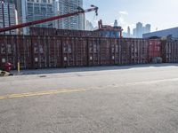 a construction worker stands near container boxes outside a building area with other containers in the background