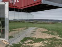 a container house with a large doorway inside of it that is attached to a pole over a grassy area