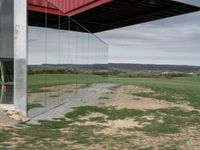 a container house with a large doorway inside of it that is attached to a pole over a grassy area