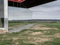 a container house with a large doorway inside of it that is attached to a pole over a grassy area