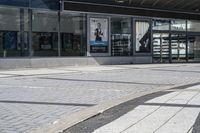 a person sitting at the bench in front of a mall that is empty of people