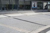 a person sitting at the bench in front of a mall that is empty of people