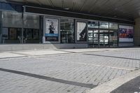 a person sitting at the bench in front of a mall that is empty of people