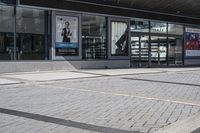 a person sitting at the bench in front of a mall that is empty of people