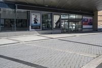 a person sitting at the bench in front of a mall that is empty of people