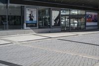 a person sitting at the bench in front of a mall that is empty of people