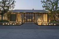 the entrance of a contemporary home, lit with candles, sits beside a glassed building