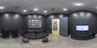 a fish eye view of some living room chairs and a flat screen tv with two empty doors