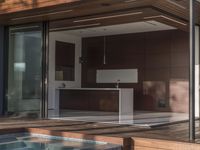 a kitchen is sitting in the pool and covered with wood walls, overlooking the courtyard