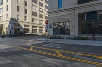 a corner street that has two yellow arrows on it as if to indicate what appears to be a parking spot