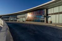 an airport building with a giant poster on it's side and a ramp for luggage