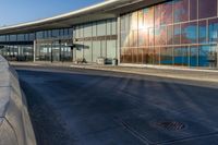 an airport building with a giant poster on it's side and a ramp for luggage