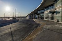 an airport building with a giant poster on it's side and a ramp for luggage