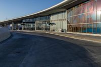 an airport building with a giant poster on it's side and a ramp for luggage