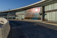 an airport building with a giant poster on it's side and a ramp for luggage