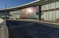 an airport building with a giant poster on it's side and a ramp for luggage