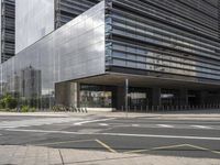 a cross walk in front of a large building with an entrance and multiple yellow lines