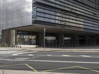 a cross walk in front of a large building with an entrance and multiple yellow lines