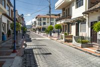 a long street with a bench at the end of it and an electrical line above