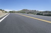 the road is empty for vehicles to drive on it's sides, a mountain in the background