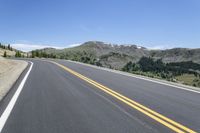 the road is empty for vehicles to drive on it's sides, a mountain in the background