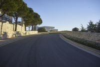 a paved road surrounded by trees in a park in the country side of europe,