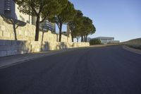 a paved road surrounded by trees in a park in the country side of europe,