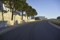 a paved road surrounded by trees in a park in the country side of europe,