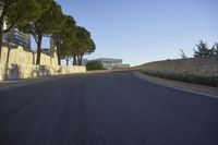 a paved road surrounded by trees in a park in the country side of europe,