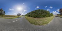 a panoramic shot of a highway intersection in the countryside area near a farm