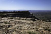 a couple hikes up a steep rocky hill to a cliff overlook overlooking a beautiful landscape