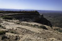 a couple hikes up a steep rocky hill to a cliff overlook overlooking a beautiful landscape