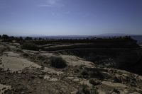 a couple hikes up a steep rocky hill to a cliff overlook overlooking a beautiful landscape