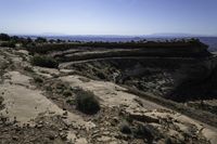 a couple hikes up a steep rocky hill to a cliff overlook overlooking a beautiful landscape