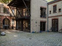 a courtyard in a building with a bicycle parked near it and other buildings around it