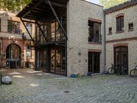 a courtyard in a building with a bicycle parked near it and other buildings around it